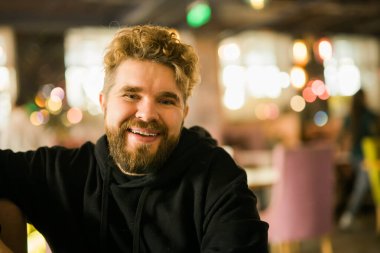 Sakallı bir programcı ya da şık bir kafede gözlüklü bir girişimci kameraya bakar ve gülümser ve reklam için boş bir alan yaratır. Freelancer uzaktan çalışıyor. Çevrimiçi iletişim videosu