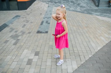 Yaz caddesinde koklear implant işitme cihazıyla yürüyen bir çocuk. İşitme kaybını tedavi etmek için modern teknolojiler.