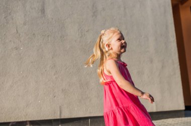 İşitme cihazı ve koklear implantları olan çocuk dışarıda eğleniyor, konuşuyor ve oynuyor. Reklam alanı ve boş yeri kopyala.