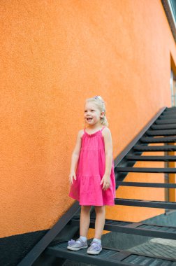 Çocuk kız kafasında koklear implantla gezer ve dışarıda eğlenir. İşitme cihazı ve tedavi konsepti. Uzayı dikey kopyala.