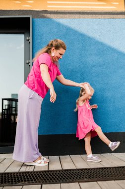 Kulakları işitmek için koklear implantı olan sağır bir çocuk yazın annesiyle dışarıda eğlenip güler. İletişim dinleme ve etkileşimde yardımcı olmak için ses uyumu aygıtı