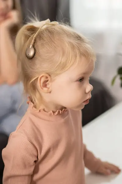 Funny Baby Cochlear Implant Sitting Home Eating Hear Aid Medicine Stock Kép