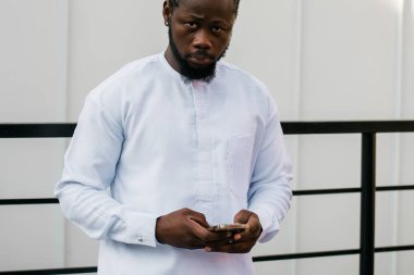 Milenyum kuşağı Afro-Amerikan erkeği açık havada internet konsepti yazıyormuş. Telefonda yüksek hızlı internet, sosyal ağlarda sohbet ve blog