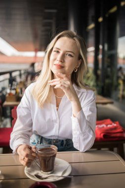 Sarışın kadın yazlık kafede sıcak çikolata içiyor. Lezzetli içecek ve mola.