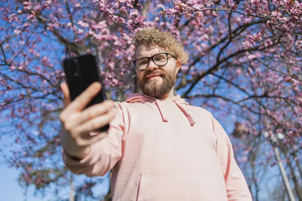 Весна Бородатый Мужчина Розовой Рубашке Говорит Телефону Весенний Розовый Цветок Лицензионные Стоковые Фото