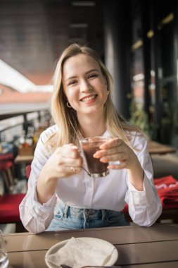 Sarışın kadın yazlık kafede sıcak çikolata içiyor. Lezzetli içecek ve mola.