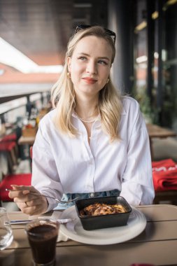 Sarışın kadın molada kafede lazanya yiyor. Kızlar restoranda vakit geçirir..