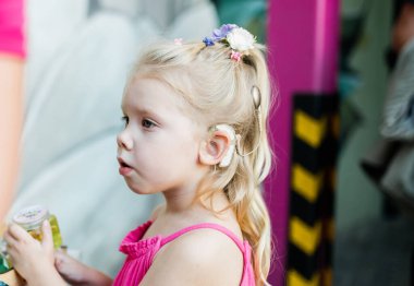 Koklear implantı olan komik bir bebek dışarıda dolaşıyor. İşitme cihazı ve tıp teknolojiyi yeniliyordu. Çeşitlilik ve kapsama. Boşluğu kopyala.