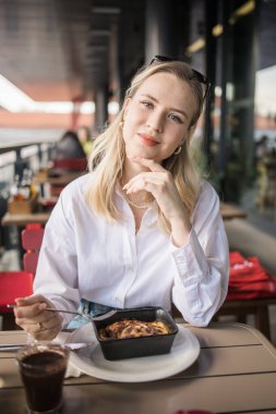 Sarışın kadın molada kafede lazanya yiyor. Kızlar restoranda vakit geçirir..