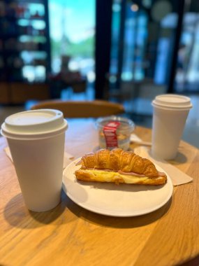 Sabah kahvesi, sütlü çay, latte ve kahve dükkanında kruvasan. Güne rahat bir kafede huzurlu bir başlangıç. Anın tadını çıkar. Sıcak ortam, yaşam tarzı keyfi ve sabah rutini.