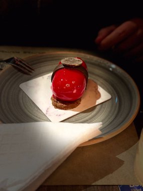 Sıcak bir restoranda servis edilen kırmızı jöleli ve çikolata süslemeli yakın çekim gurme tatlı..
