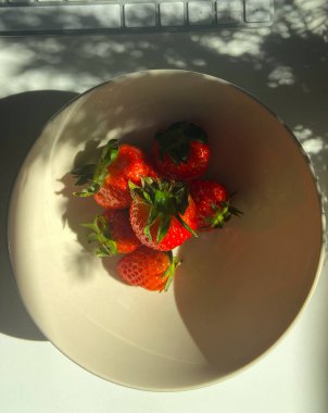 Bej renkli seramik kasede taze çilekler..