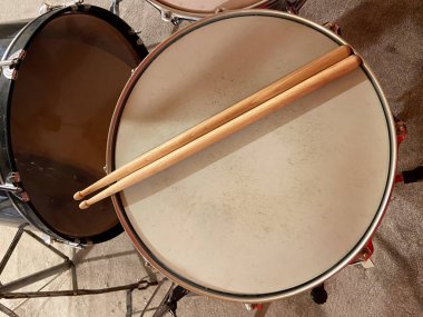 Ahşap bagetler trampetin üzerinde duruyor, ritmi ve enerjiyi davet ediyor. Bu samimi ortamda müzik deneyimi gözler önüne serilecek..
