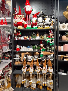 Noel mağazasındaki raflar tuhaf cüce figürleri ve bayram süslemeleriyle süslenmiş. Tatil indirimi.