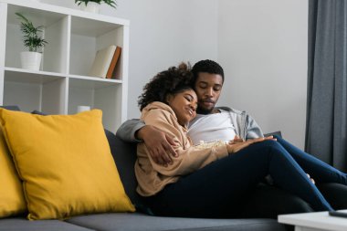 Genç Afro-Amerikan çift evde televizyon izliyor. Akış ve TV dizisi konsepti.