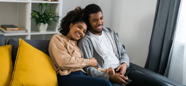 Genç Afro-Amerikan çift evde televizyon izliyor. Akış ve TV dizisi konsepti.