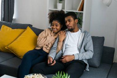 Genç Afro-Amerikan çift evde televizyon izliyor. Akış ve TV dizisi konsepti.