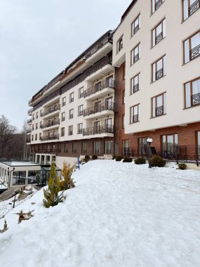 Kışın yeşil alanda yeni modern apartman blokları. Düz binaları olan bir apartman dairesi. Lüks ev kompleksi karla kaplı. Şehir Emlak Mülkü Mimarlık Sigortası Konsepti