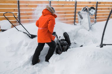 Kızıl Kar Fırtınası iş başında. Bahçede kar temizleme makinesi kullanan bir adam evin önünde bekliyor. Kışın evin dışında kar atıcısı. Kar üfleyen genç işçi..