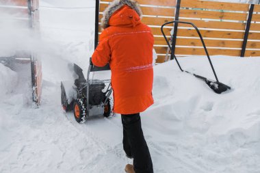Kızıl Kar Fırtınası iş başında. Bahçede kar temizleme makinesi kullanan bir adam evin önünde bekliyor. Kışın evin dışında kar atıcısı. Kar üfleyen genç işçi..