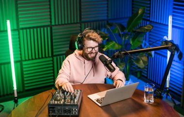 Canlı yayında gülümseyen bir milenyum adamıyla mikrofon, talk show ya da eğlence sunucusu olarak. Erkek içerik yaratıcısı ve ses veya sosyal kayıt için podcast sunucusunda mutlu.