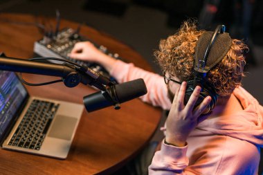 Neşeli genç adam stüdyoda podcast yapıyor. Kulaklığı ve mikrofonu olan kendine güvenen bir adam podcast kaydediyor. İnternet radyosunda konuşan mutlu adam.