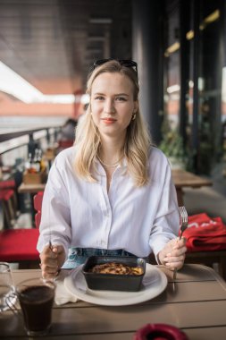 Sarışın kadın molada kafede lazanya yiyor. Kızlar restoranda vakit geçirir..