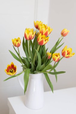 Masadaki beyaz sürahide bir buket lale. Doğa, ev dekorasyonu ve bahar kavramı