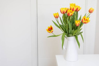 Masadaki beyaz vazoda lale buketi. Doğa, ev dekorasyonu ve bahar kavramı.