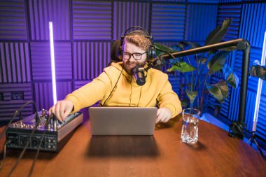 Canlı yayında gülümseyen bir milenyum adamıyla mikrofon, talk show ya da eğlence sunucusu olarak. Erkek içerik yaratıcısı ve ses veya sosyal kayıt için podcast sunucusunda mutlu.