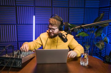 Canlı yayında gülümseyen bir milenyum adamıyla mikrofon, talk show ya da eğlence sunucusu olarak. Erkek içerik yaratıcısı ve ses veya sosyal kayıt için podcast sunucusunda mutlu.