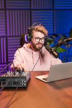 Canlı yayında gülümseyen bir milenyum adamıyla mikrofon, talk show ya da eğlence sunucusu olarak. Erkek içerik yaratıcısı ve ses veya sosyal kayıt için podcast sunucusunda mutlu.