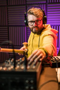 Ses mühendisi butik kayıt stüdyosundaki miksaj panelinde çalışıyor.