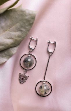 Mücevherli gümüş küpe seti. Mücevherler minimalist tarzda dizilmiş. El yapımı bijouterie konsepti