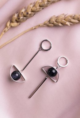 Mücevherli gümüş küpe seti. Mücevherler minimalist tarzda dizilmiş. El yapımı bijouterie konsepti