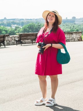 gülümseyen genç kadın dışarıda parkta çekmek için bir kamera ile