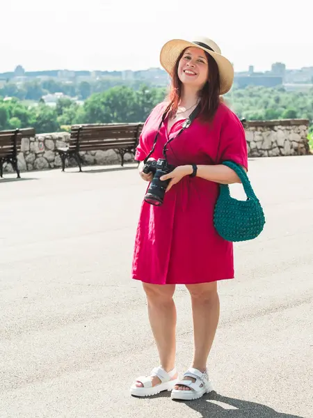 gülümseyen genç kadın dışarıda parkta çekmek için bir kamera ile