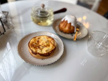 Kafe masasında bitkisel çayla servis edilen turta ve jöleli kek. Sıcak bir mola ve hafif tatlı yiyeceklerle yavaş bir yaşam tarzı..