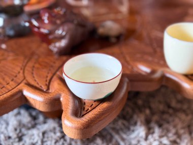 Geleneksel çay toplantılarında seramik çay fincanı dikkatle konur. Çay seremonisinin sessiz güzelliği ve onun meditasyon atmosferi.