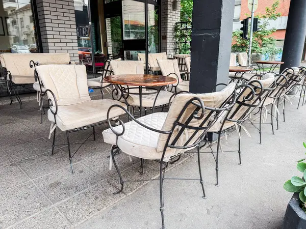 Antika sandalyeli açık kafe teras ve şehir ortamında boş yuvarlak masalar. Halk eğlencesi ve şehir kahve kültürü.