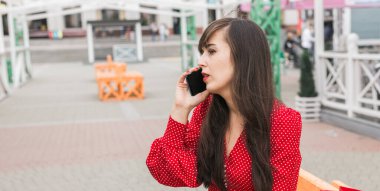 Kadın dışarıda alışveriş yaptıktan sonra telefon görüşmesi yapıyor. Satın alma hakkında iletişim ve paylaşım deneyimleri
