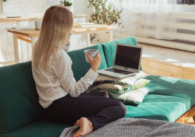 Uzaktan çalışan bir kadın akıllı telefondan konuşuyor. İletişim, serbest çalışma ve modern ev yaşam tarzı teması