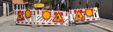İnşaat için cadde kapalı. Uyarı levhaları ve kazıcıyla trafik engelleri yerleşim bölgesinde görülebilir