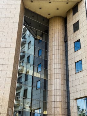 Şehir ortamında yerleşim mimarisini yansıtan cam cephe. Resim kentsel simetri ve yapısal karşıtlığı iletir