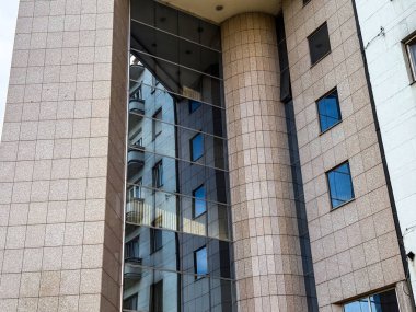 Şehir ortamında yerleşim mimarisini yansıtan cam cephe. Resim kentsel simetri ve yapısal karşıtlığı iletir