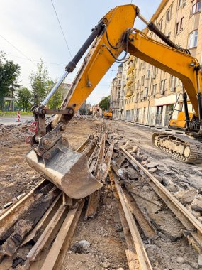Kazıcı gün batımında eski tramvay raylarını kaldırıyor. Kentsel ulaşım yenileniyor