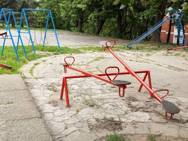 Boş bir oyun alanında renkli tahterevalliler ve salıncaklar. Çocuklar için oyun ve eğlence için sakin bir şehir alanı