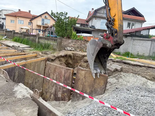 Kazıcı yerleşim alanında çalışıyor. Kentsel altyapı, inşaat mühendisliği ve kenar mahallelerde devam eden inşaat.