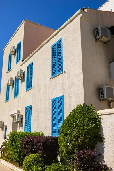 Kapalı mavi panjurlu bir cephe. Akdeniz mimarisi, güneşli iklim ve kıyı binalarında yaz yaşam tarzı.