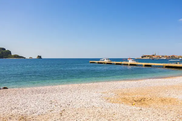 Sahil kasabası yakınlarında tekneler. Karadağ 'da deniz turizmi, deniz taşımacılığı ve Budva manzarası